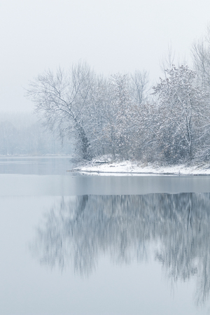 Winter lake scene reflecting in the waterの写真素材