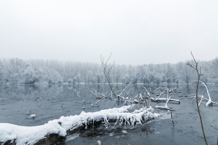 Frozen lake in winter, Winter lake scene reflecting in the waterの写真素材