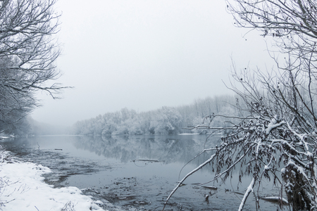 Winter lake scene reflecting in the waterの写真素材