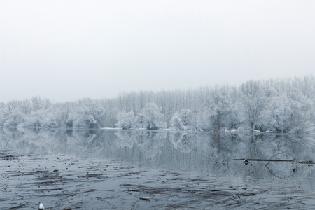 Frozen lake in winter, Winter lake scene reflecting in the waterの写真素材