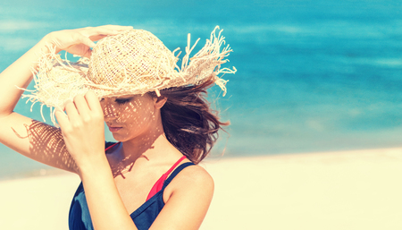 Beautiful girl in a straw hat, traveller woman on tropical beachの写真素材