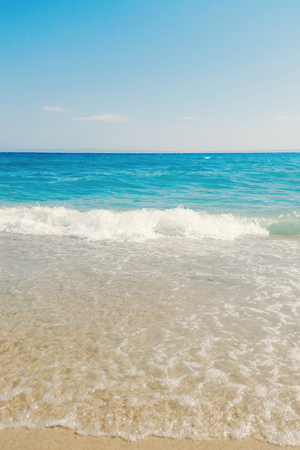 Wave of blue ocean on sandy beach close up Summer Backgroundの写真素材
