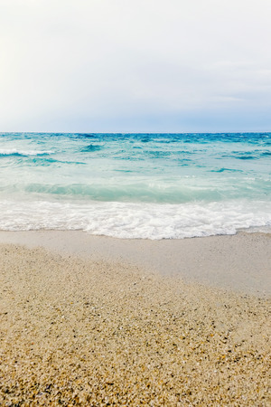 Wave of blue ocean on sandy beach close up Summer Backgroundの写真素材