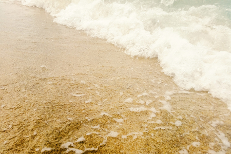 Wave of blue ocean on sandy beach close up Summer Backgroundの写真素材