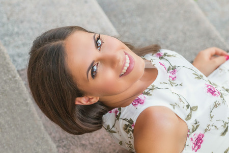 Sensual young brunette woman portrait outdoors sitting on stairsの写真素材