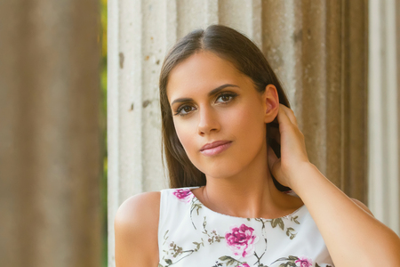 Beautiful brunette young woman wearing nice dress flower pattern. Fashion photo.の写真素材