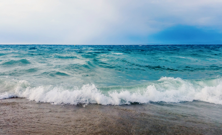 Strong waves crash over the beach Beautiful seascape.の写真素材