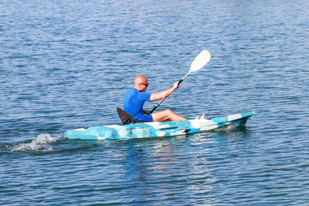 Young Kayaker Paddling Kayak. Sportsman kayaking Blue Water.の写真素材