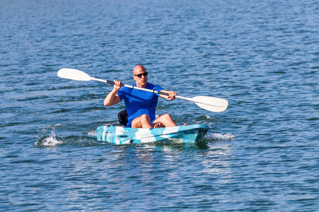 Young Kayaker Paddling Kayak. Sportsman kayaking Blue Water.の写真素材