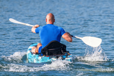 Young Kayaker Paddling Kayak. Sportsman kayaking Blue Water.の写真素材