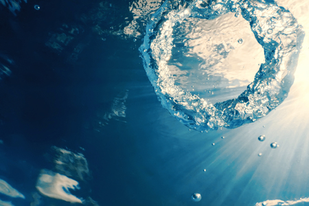Bubble ring Underwater ascends towards the sun.の写真素材