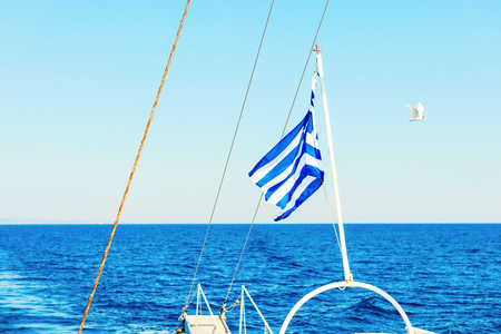 Greek flag waving at the back of a boatの写真素材
