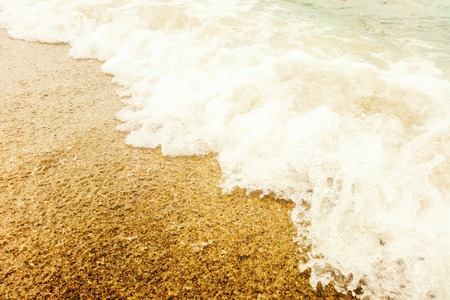 Wave of blue ocean on sandy beach close up Summer Backgroundの写真素材