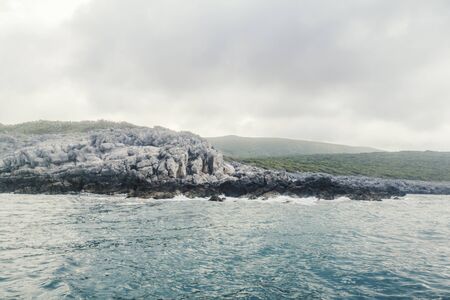 Sea Landscape Waves Crashing against the Rocky Shoreline, Cloudy Skyの写真素材