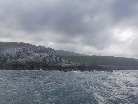 Sea Landscape Waves Crashing against the Rocky Shoreline, Cloudy Skyの写真素材
