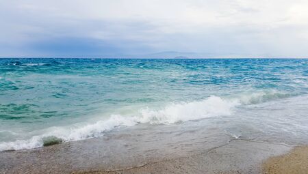 Strong waves crash over the beach Beautiful seascape.の写真素材