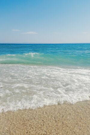 Wave of blue ocean on sandy beach close up Summer Backgroundの写真素材