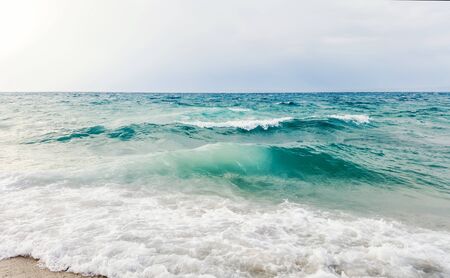 Strong waves crash over the beach Beautiful seascape.の写真素材