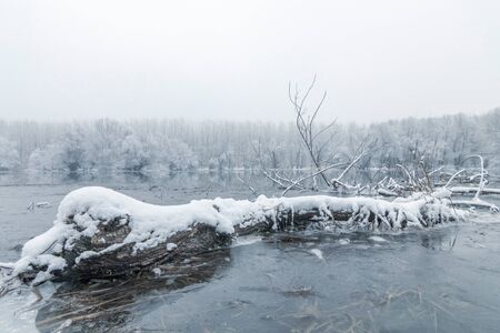 Frozen lake in winter, Winter lake scene reflecting in the waterの写真素材