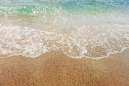 Wave of blue ocean on sandy beach close up Summer Background