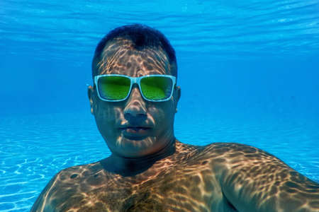 Pool Summer Party, Man with Sunglasses Underwater in Swimming Poolの写真素材
