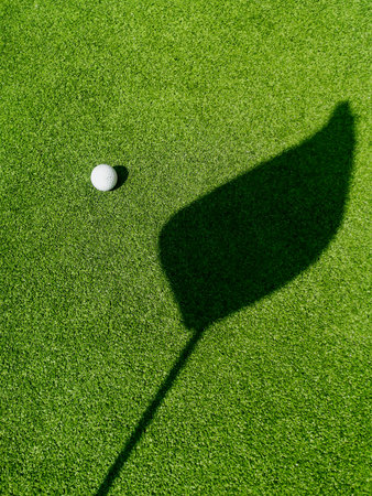 Golf ball on the green, shadow of a flagÂ on a green,Â golf course