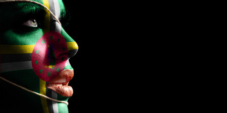 Dominica flag painted on a face of a young woman, national flag on faceの写真素材