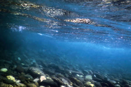 Rocks underwater on riverbed, rivers freshwater underwater, crystal clear water, pebbles on riverbedの写真素材