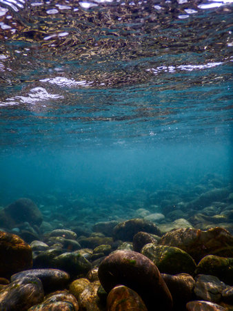 Rocks underwater on riverbed, rivers freshwater underwater, crystal clear water, pebbles on riverbedの写真素材