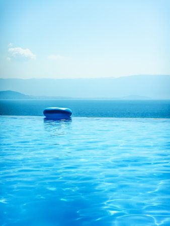 Infinity swimming pool with sea and Mountain View, blue floatの写真素材