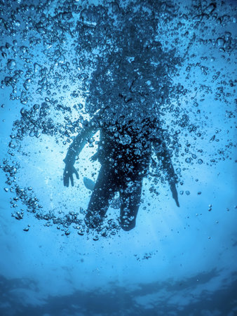 Scuba Diver Silhouettes Clear Blue Waterの写真素材