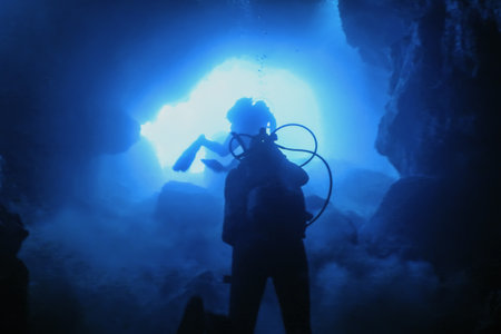 Scuba Divers Silhouette in Underwater Caveの写真素材