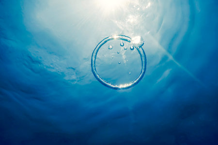 Bubble Ring Underwater Ascends Towards The Sunの写真素材