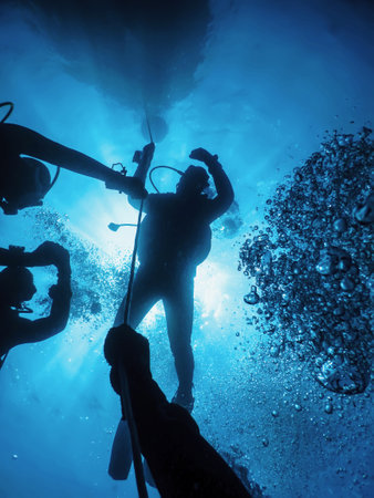 Group of Divers on Safety Stop Underwater Bubbles, Sunlightの写真素材