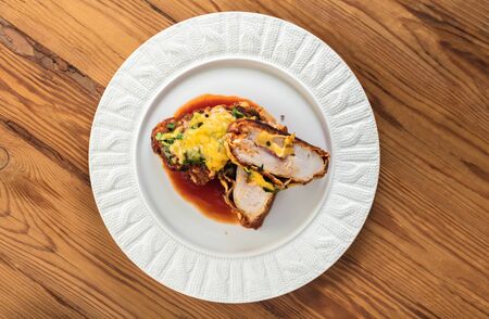 baked chicken fillet with cheese on a wooden backgroundの写真素材