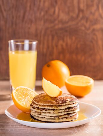 Pancake with orange juice on a wooden backgroundの写真素材