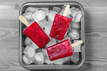 Frozen juice on stick closeup with ice cubesの写真素材