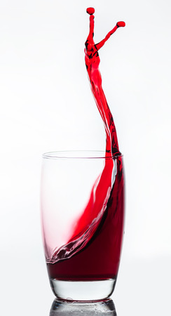 splash of drink from a glass with reflectionの写真素材