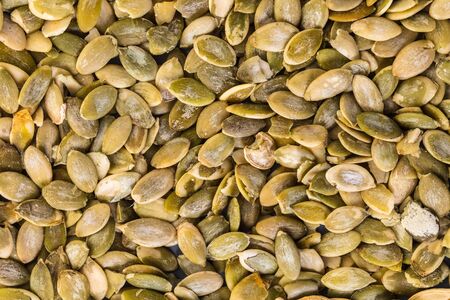 food background, texture of pumpkin seeds close-upの写真素材