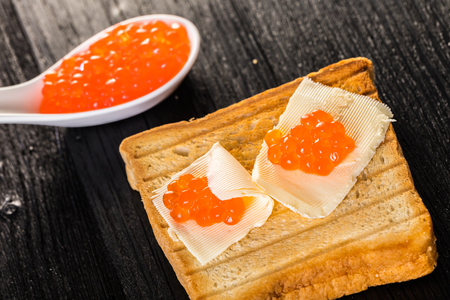 Toast with butter and caviar black wooden backgroundの写真素材
