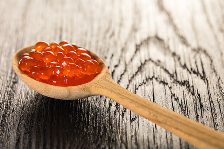 red caviar in spoon on wooden backgroundの写真素材