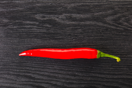 hot chili pepper on a black wooden backgroundの写真素材