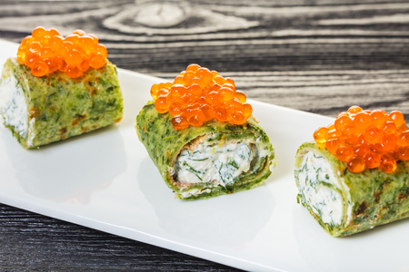 pancakes with spinach and red caviar on wooden backgroundの写真素材