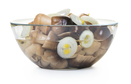 Pickled mushrooms in a glass bowl on white isolated backgroundの写真素材