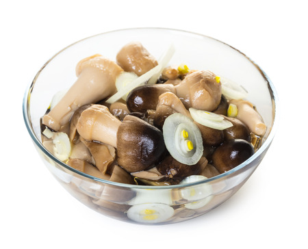Pickled mushrooms in a glass bowl on white isolated backgroundの写真素材