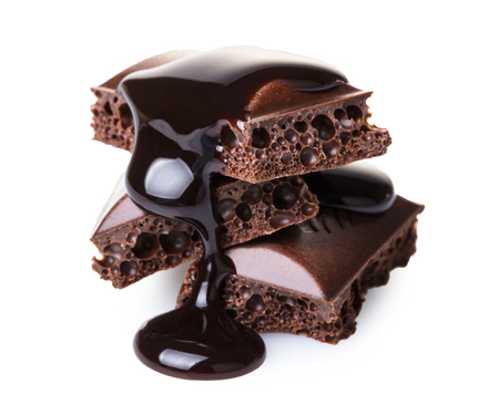 pieces of porous chocolate on white isolated backgroundの写真素材
