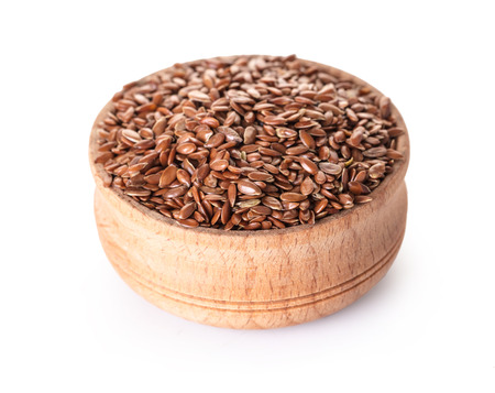 wooden bowl with flax seeds on white isolated backgroundの写真素材