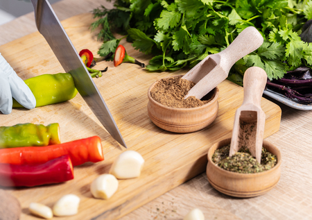 cook cutting hot chili peppers on a wooden boardの写真素材