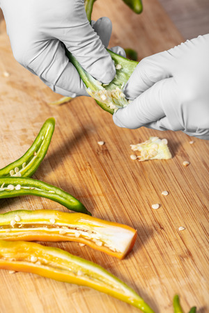 cook cleans hot green pepper, hands closeupの写真素材