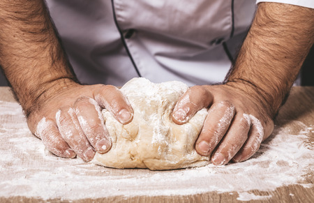 male chef kneads the dough, hands closeupの写真素材